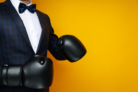 Businessman in boxing gloves on yellow backgroundの写真素材