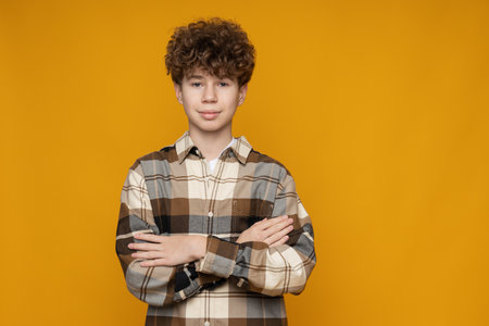 Attractive boy, teenager in shirt on yellow backgroundの写真素材