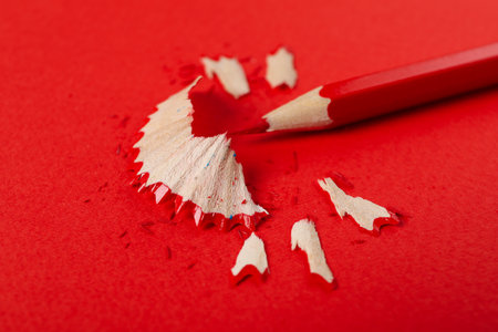 Red pencil on red background, close upの写真素材