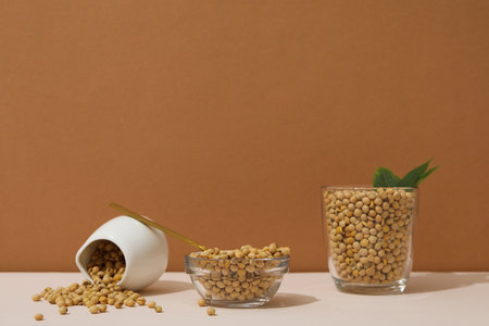 Soy seeds on white table against brown backgroundの写真素材