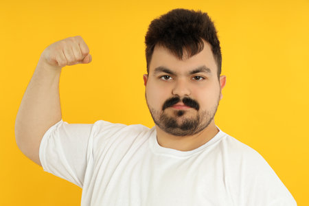 Concept of people, young fat man on yellow backgroundの写真素材