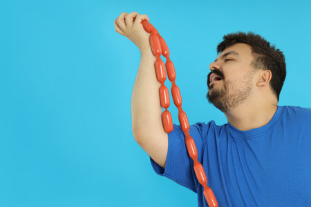 Concept of excess weight, fat guy with food on blue backgroundの写真素材