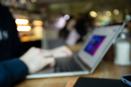 Young man working on modern laptop, blurred photoの写真素材