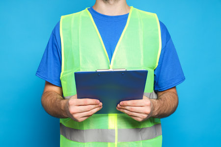 Civil engineer with clipboard on blue backgroundの写真素材