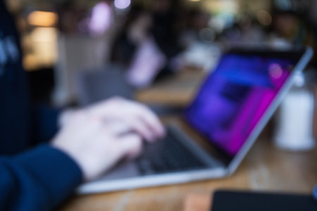 Young man working on modern laptop, blurred photoの写真素材