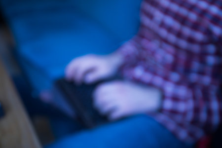 Young man working on modern laptop, blurred photoの写真素材