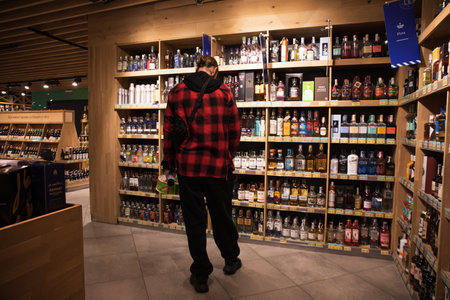 Man chooses an alcohol product in supermarket