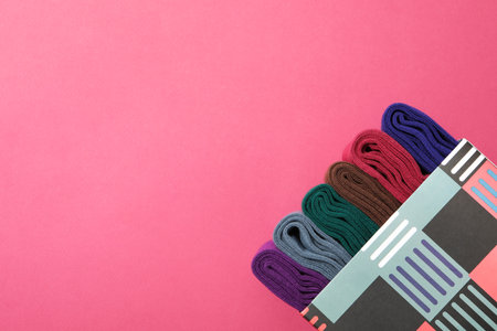 Box with socks on pink background, space for textの写真素材