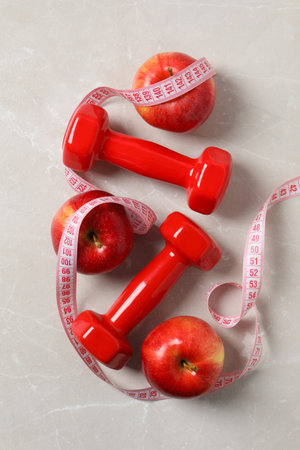 Concept of weight loss and healthy nutrition with apple and measuring tapeの写真素材