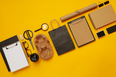 Mockup flat lay with different office accessories on yellow backgroundの写真素材