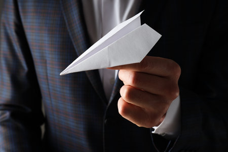 Businessman with paper plane, close up and selective focusの写真素材