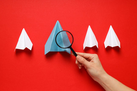 Business, startup and sponsorship concept with paper planes on red backgroundの写真素材