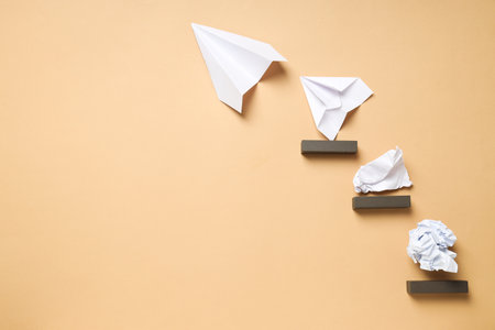 Business, startup and sponsorship concept with paper planes and paper on beige backgroundの写真素材