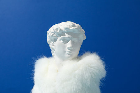 Ancient head in fur against blue background