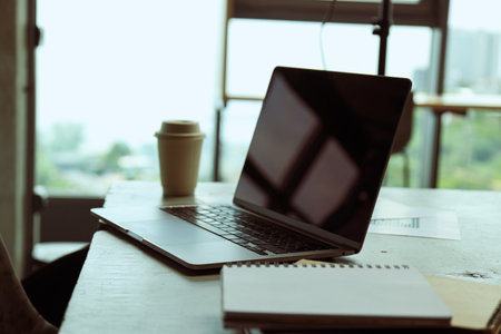 Office table with coffee, laptop and office papers, notebooksの写真素材