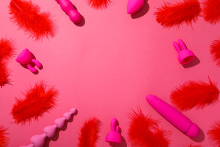 Pink sex toys with feathers on a pink backgroundの写真素材