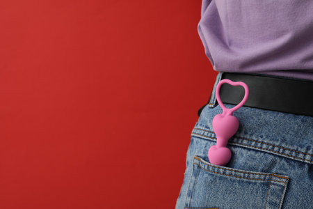 Anal chain in the pocket of jeans on a red backgroundの写真素材