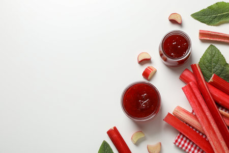 Rhubarb stalks, jars of jam, mint on white background, space for textの写真素材
