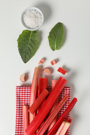 Rhubarb stalk on a checkered towel, mint, bowl with salt on a white backgroundの写真素材
