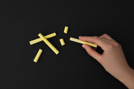 A piece of chalk in a hand on a black backgroundの写真素材