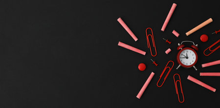 Multicolored pieces of chalk with a clock on a black background, place for textの写真素材