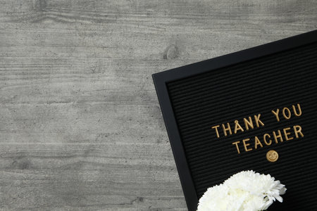 Black frame with text and white flowers on wooden background, space for textの写真素材