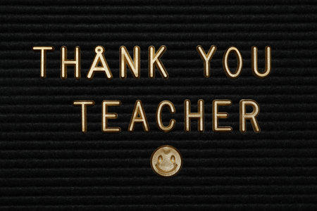 Golden letters and emoji on black background, close upの写真素材