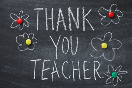 Black school board with chalk inscription "Thank you teacher!"の写真素材