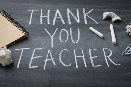 Black school board with chalk inscription "Thank you teacher!"の写真素材