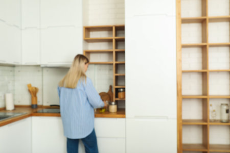 A young woman is preparing breakfast in the kitchenの写真素材
