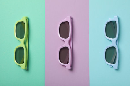 Blue, purple and green glasses on colorful background, top view
