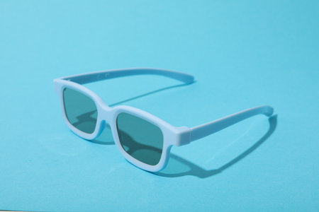 Blue sunglasses on blue background, close upの写真素材