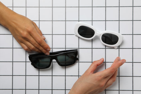 A pair of sunglasses on a checkered black and white backgroundの写真素材