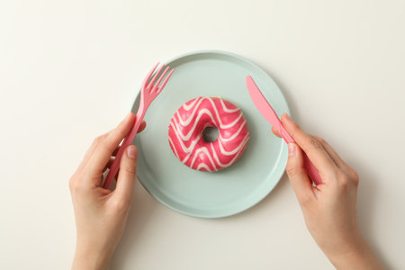 Pink donut on a plate, on a light backgroundの写真素材