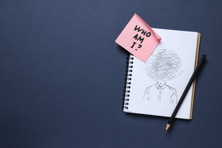 Notepad with pencil drawing and pink note with text on dark blue background, space for textの写真素材