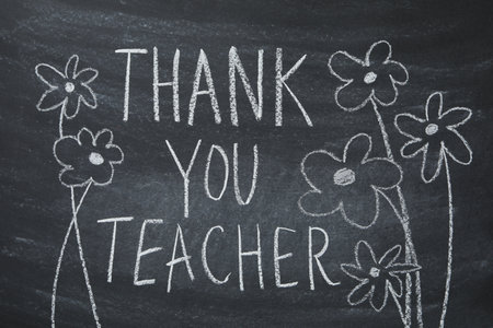 Black school board with chalk inscription "Thank you teacher!"の写真素材