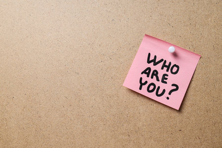 Pink sticky note with text on beige background, space for textの写真素材