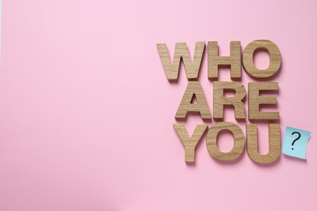 Text from wooden letters on pink background, space for text