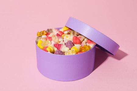 Purple box with jelly candies on pink backgroundの写真素材