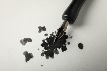 Ink blot and pen on white background, close upの写真素材