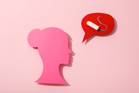 Female pink silhouette with a tampon, on a pink backgroundの写真素材
