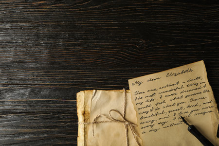 Old letters, letter with text and pen on wooden background, space for textの写真素材
