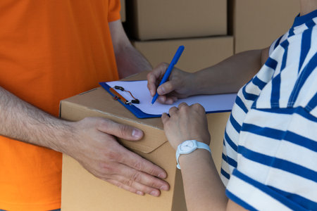 The client signs for receiving the packageの写真素材