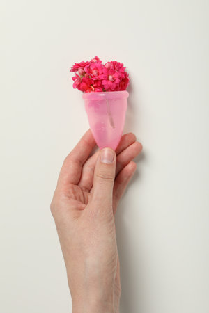 Menstrual cup with flowers inside, in hand