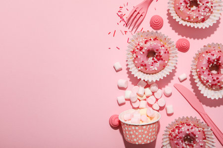 Donuts, jelly candies and marshmallows on pink background, space for textの写真素材