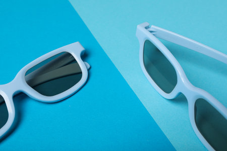 Blue glasses with dark lenses on blue background