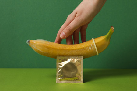A condom on a banana on a green backgroundの写真素材