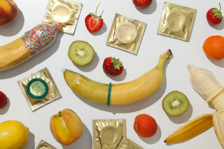 Condoms on bananas with fruit on a light backgroundの写真素材