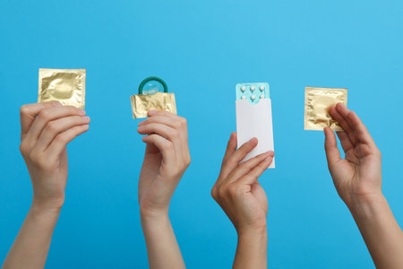 Condoms in hand on a blue backgroundの写真素材