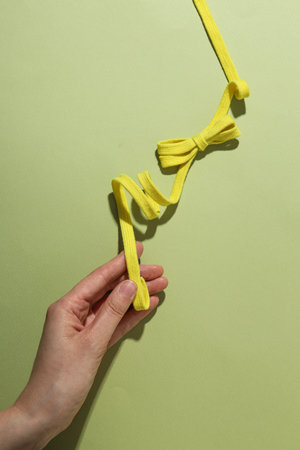A knot of yellow braided lace on a light backgroundの写真素材